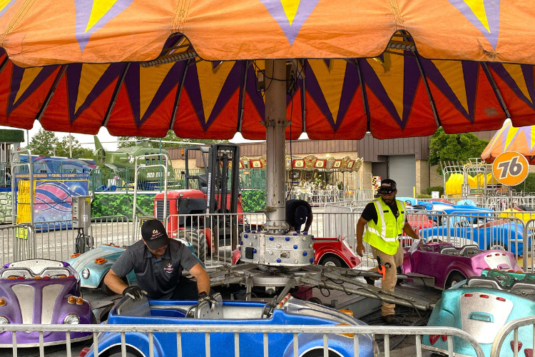 At the Maryland State Fair, three inspectors examine a kids' ride with cars that move in a circle.
