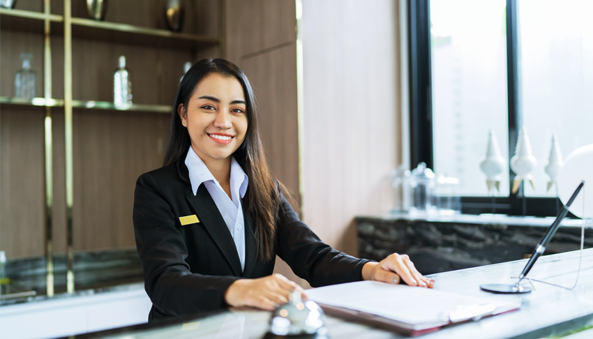Overhead view of a woman working at the front desk of a hotel on the phone